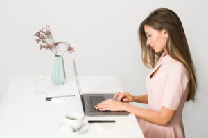 woman sitting while using laptop